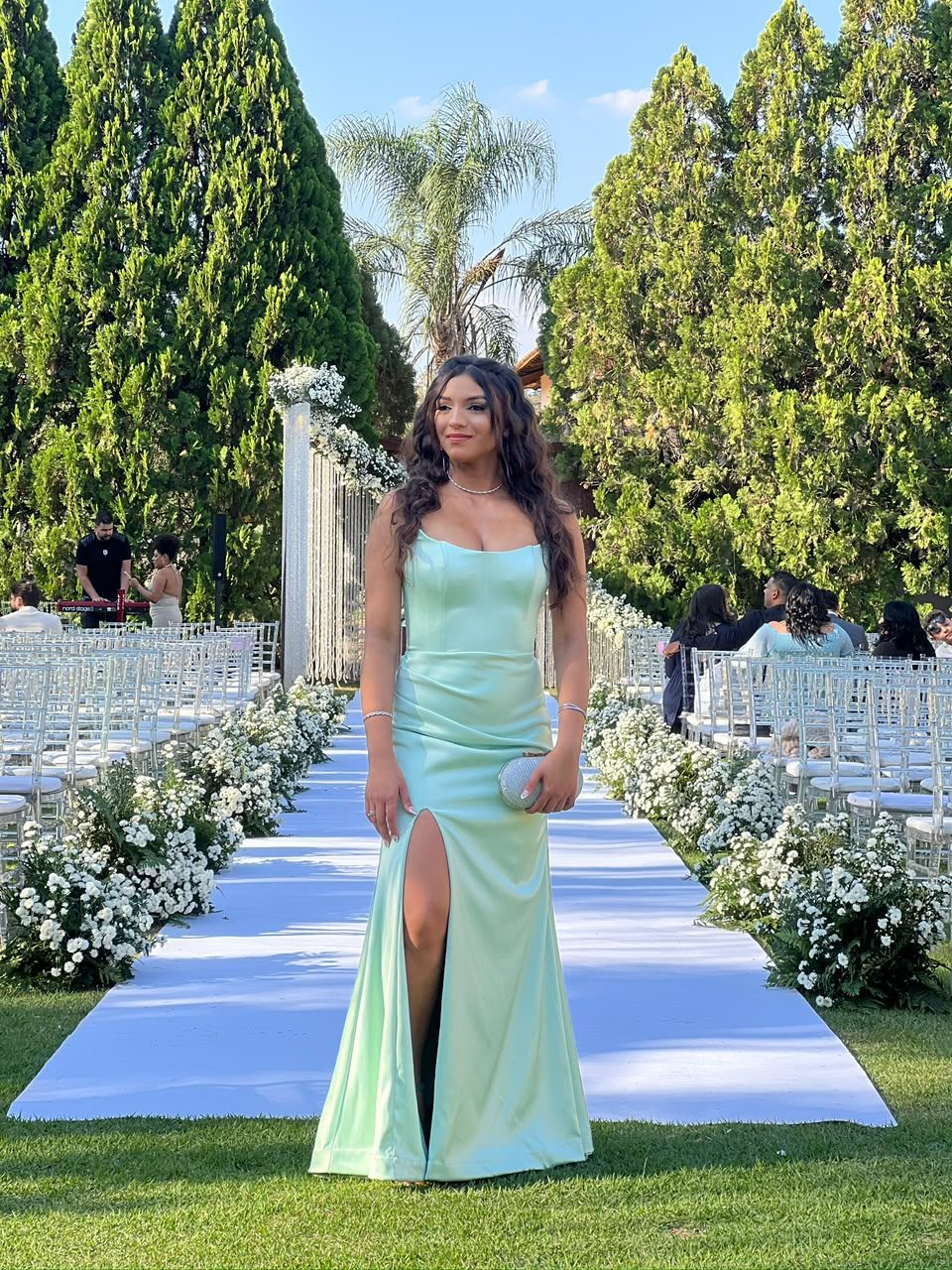 Modelo com vestido verde-menta acetinado, no jardim